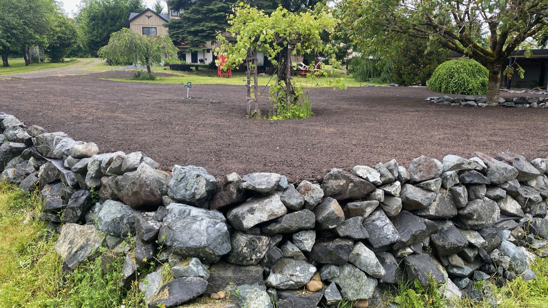 Finished stone retaining wall surrounding the planted terrace